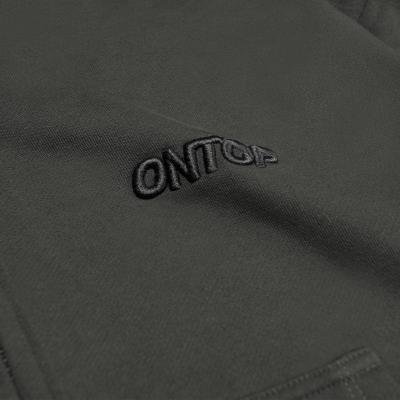 Close-up of a brand logo on a dark fabric surface