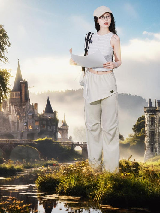 Woman in a white outfit standing in front of a castle with a scenic background