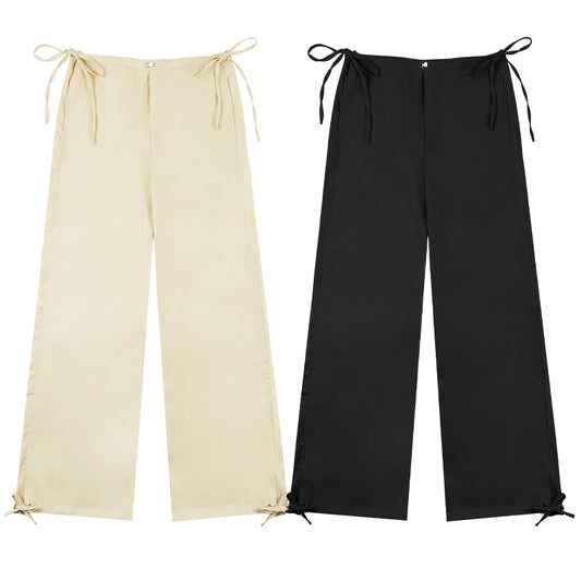 Beige and black wide-leg pants with tie details on a white background