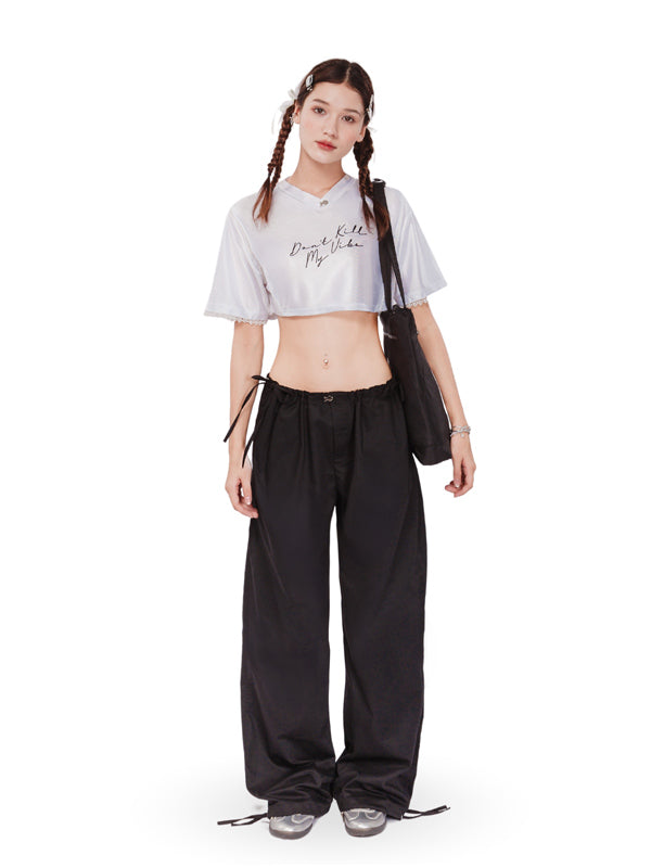 Person wearing a white crop top and black pants with a white background