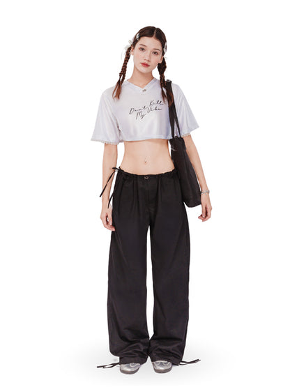 Person wearing a white crop top and black pants with a white background