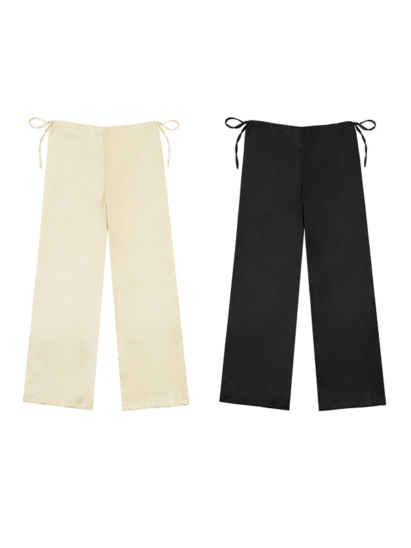 Two pairs of wide-leg pants, one beige and one black, on a white background.