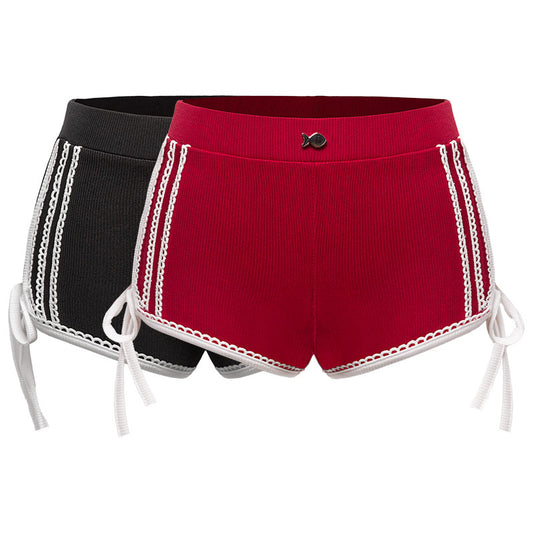 Black and red shorts with white lace trim on a white background