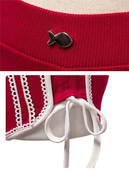 Red garment with a fish-shaped button and white lace details on a beige background