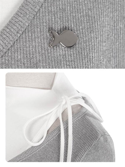 Gray knit garment with a small fish-shaped button and white drawstring.