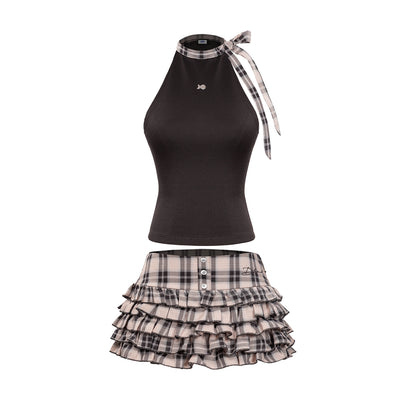Black top with plaid ribbon and plaid skirt on a white background