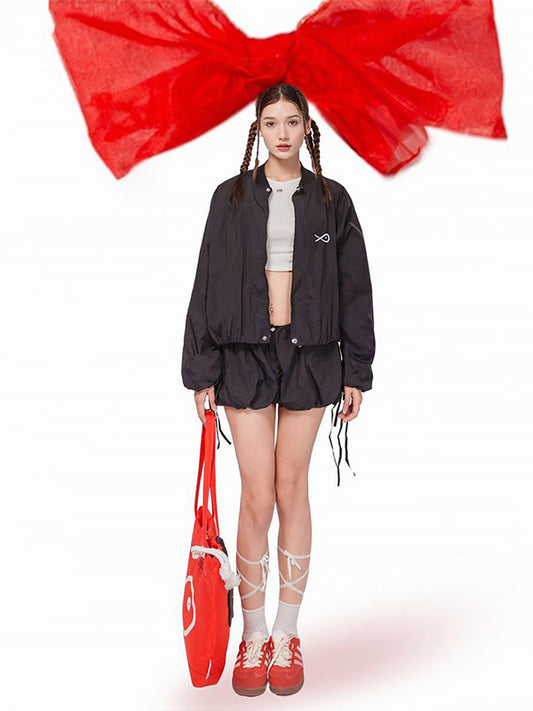 Person wearing a black outfit with red props on a white background