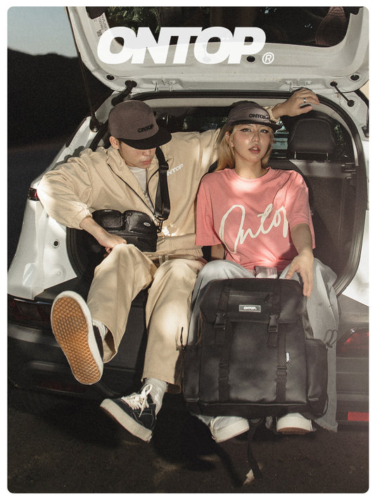 Two people sitting in the back of a car with ONTOP branding.