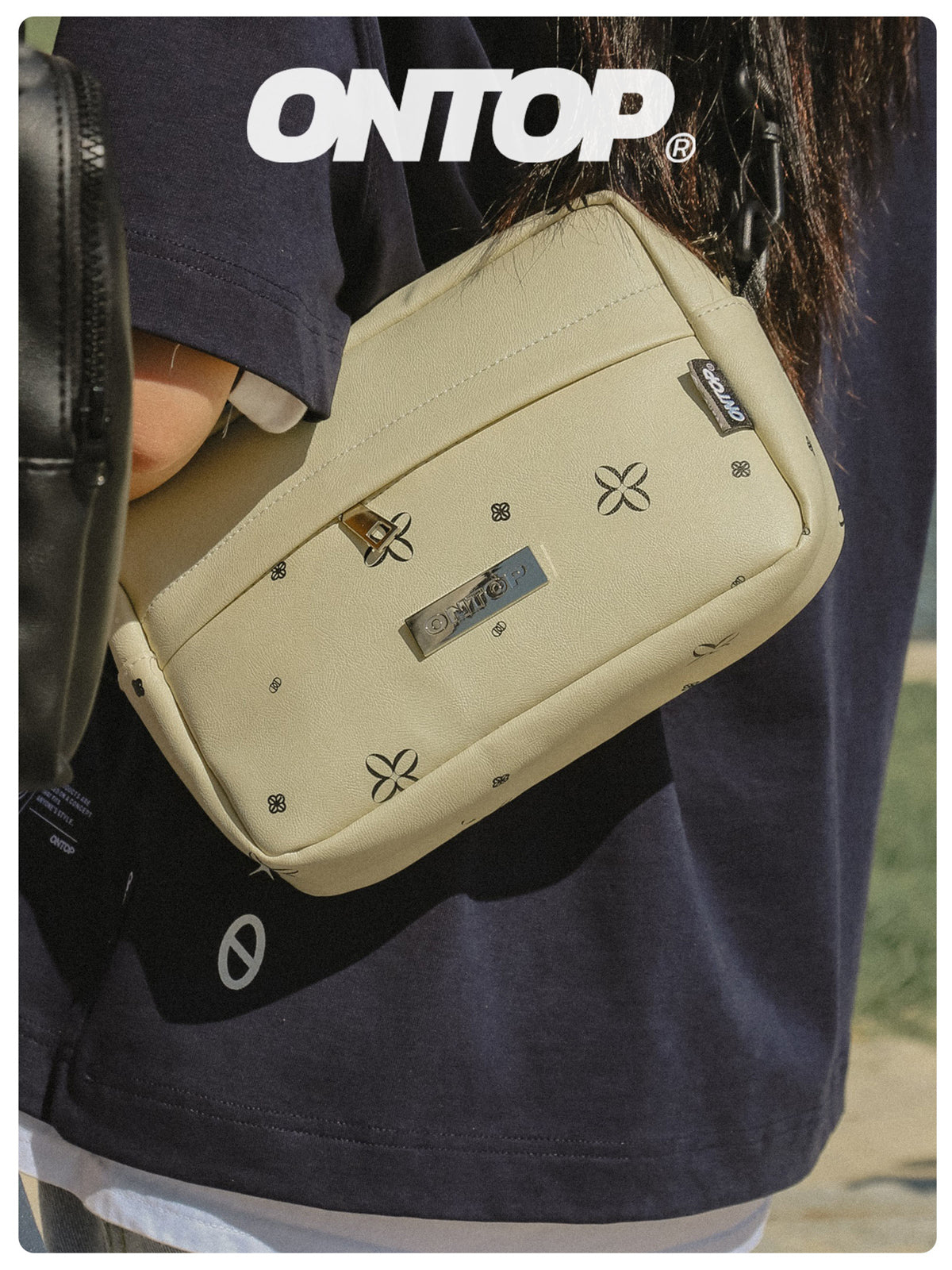 Beige waist bag with brand logo on a person wearing a navy shirt