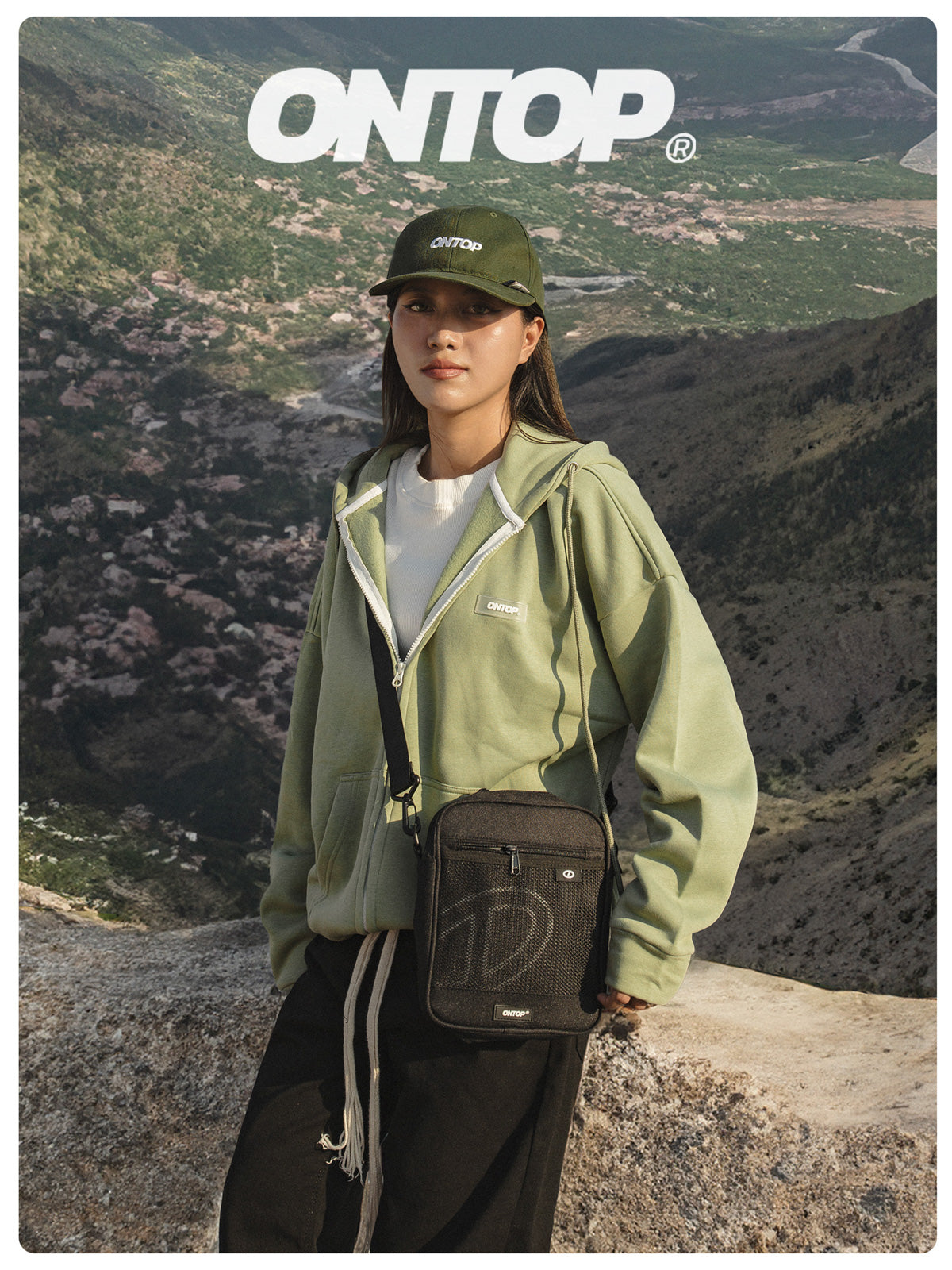 Person wearing a green jacket and cap with a bag, standing on a mountainous landscape, featuring the brand 'ONTOP'.