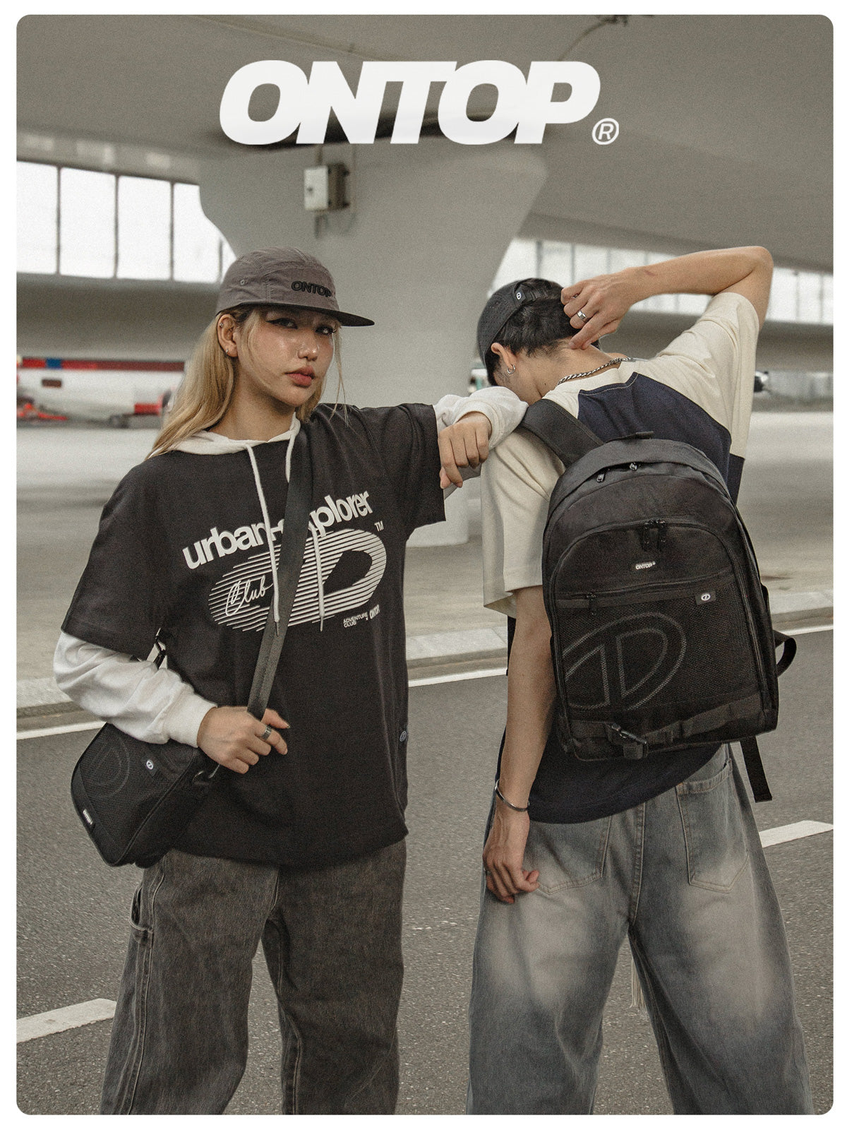 Two people standing together, one holding a backpack with 'ONTOP' branding, in an indoor setting.