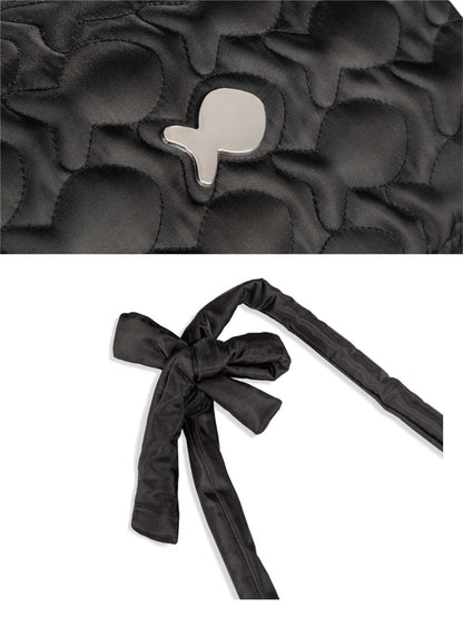 Black quilted bag with floral pattern and black ribbon on a white background