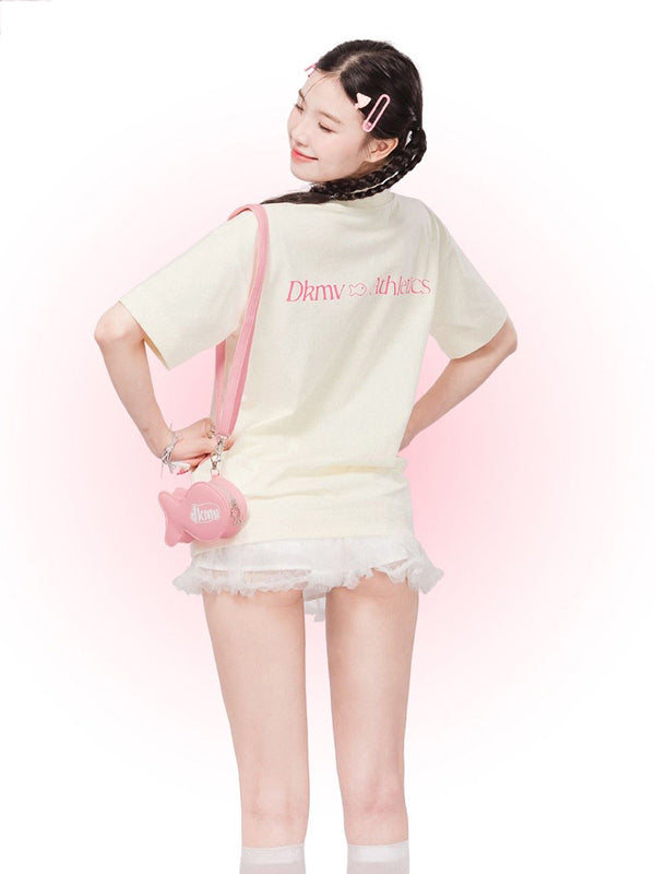 Woman wearing a light-colored outfit with a pink bag on a white background