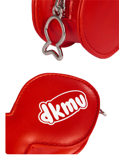 Red leather pouch with a cat-shaped keychain and 'dkmv' logo on a white background