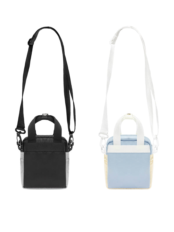 Black handbag with strap and light blue handbag with white strap on a white background