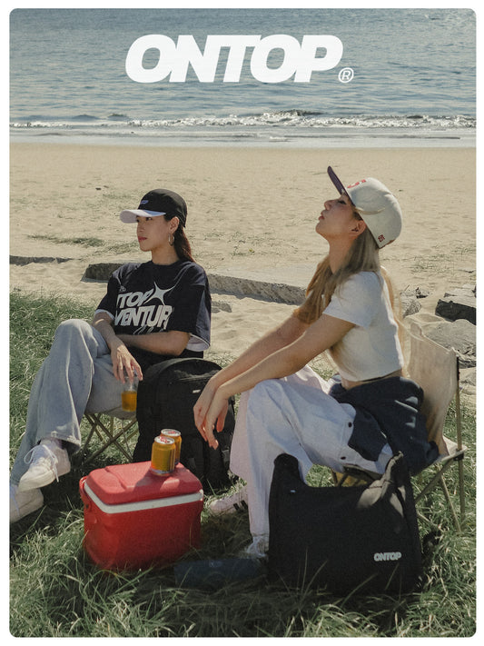 Two people sitting on chairs by the beach with a cooler and drinks, featuring the 'ONTOP' brand.