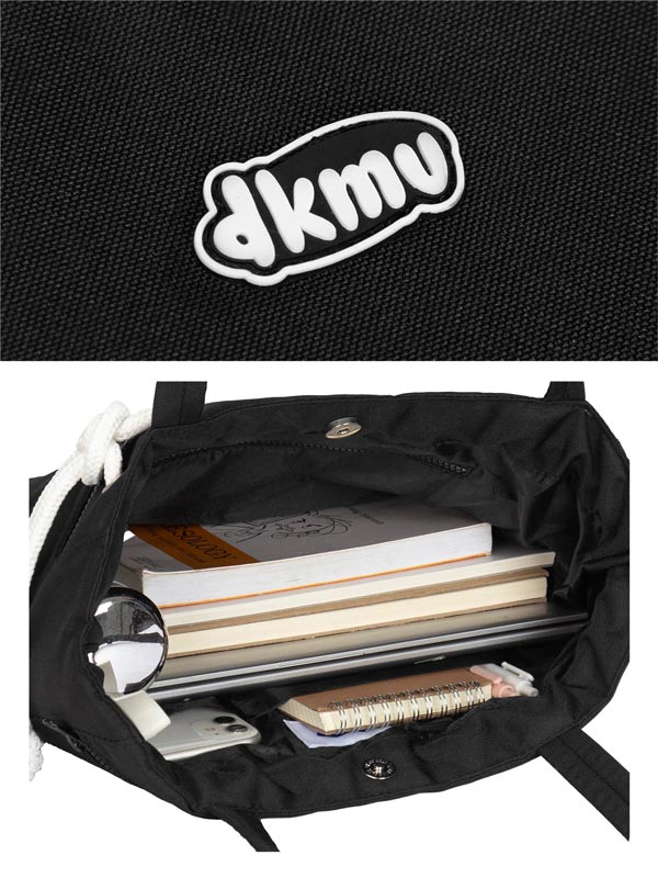 Black bag with books and a phone inside, featuring the 'dkmv' logo on a black background.