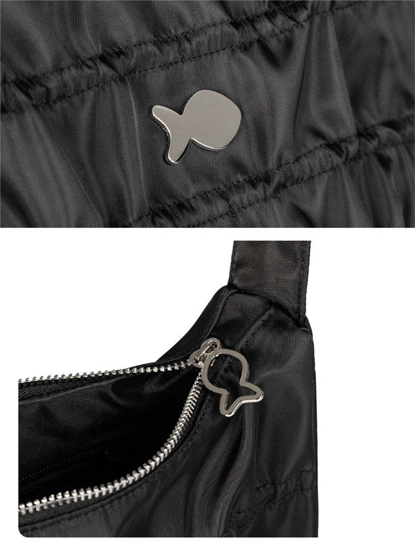 Close-up of a black jacket with a fish-shaped button and zipper detail.