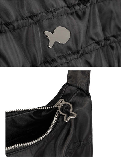 Close-up of a black jacket with a fish-shaped button and zipper detail.