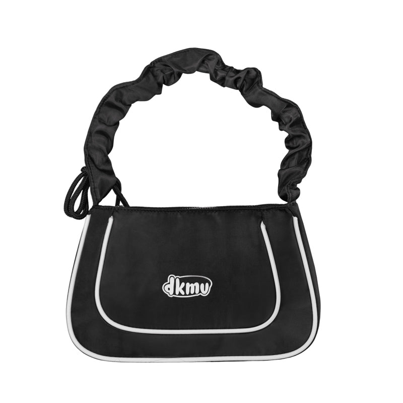 Black dog carrier with white trim and 'dkmv' logo on a white background