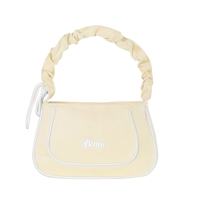 Light yellow handbag with white accents and 'dkny' logo on a white background