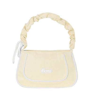 Light yellow handbag with white accents and 'dkny' logo on a white background