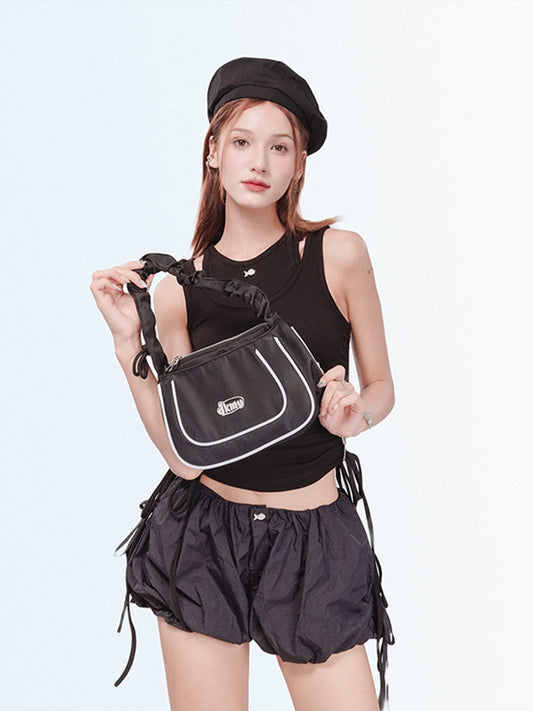 Person holding a black bag against a white background