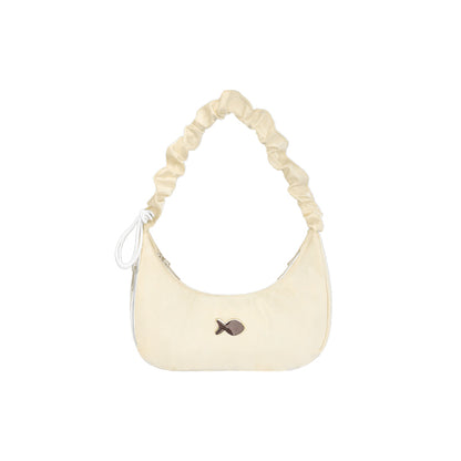 Cream-colored handbag with a fish charm on a white background