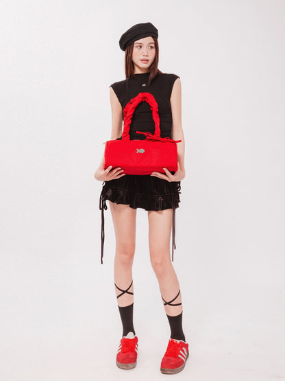 Person holding a red handbag against a white background