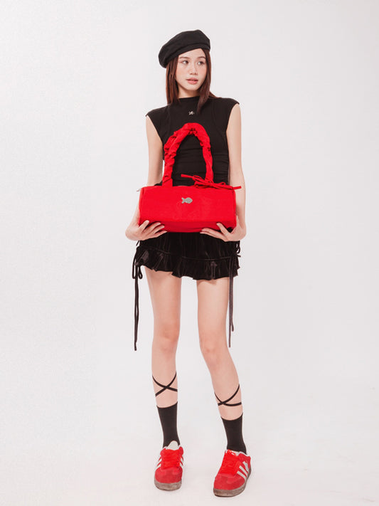 Person holding a red handbag against a white background
