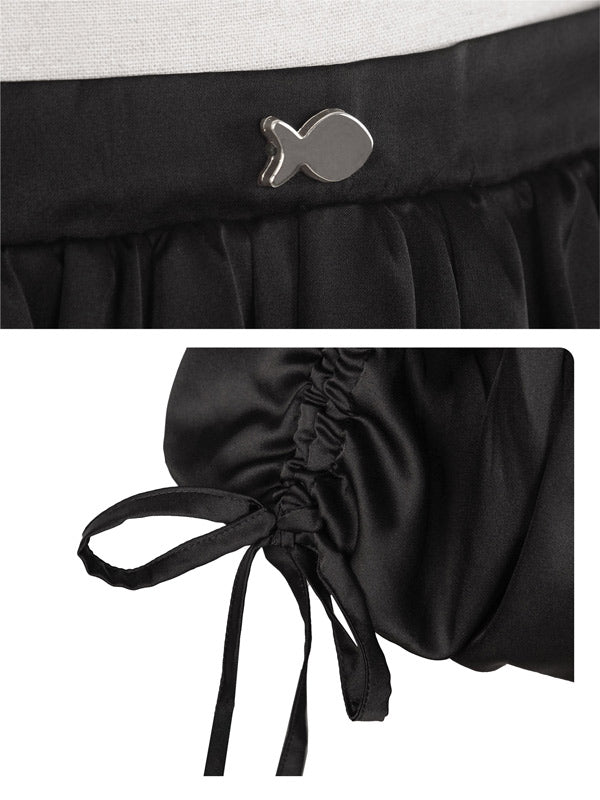 Black skirt with fish-shaped button and tied waistband on a white background