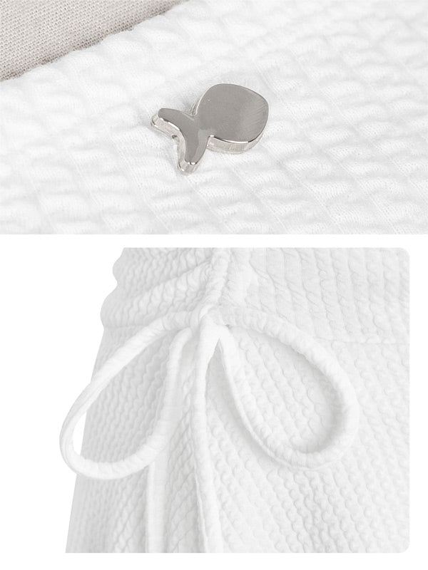 Silver earring on a textured white surface