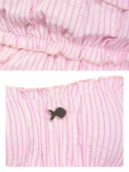Pink striped fabric with a small black fish-shaped object on a white background