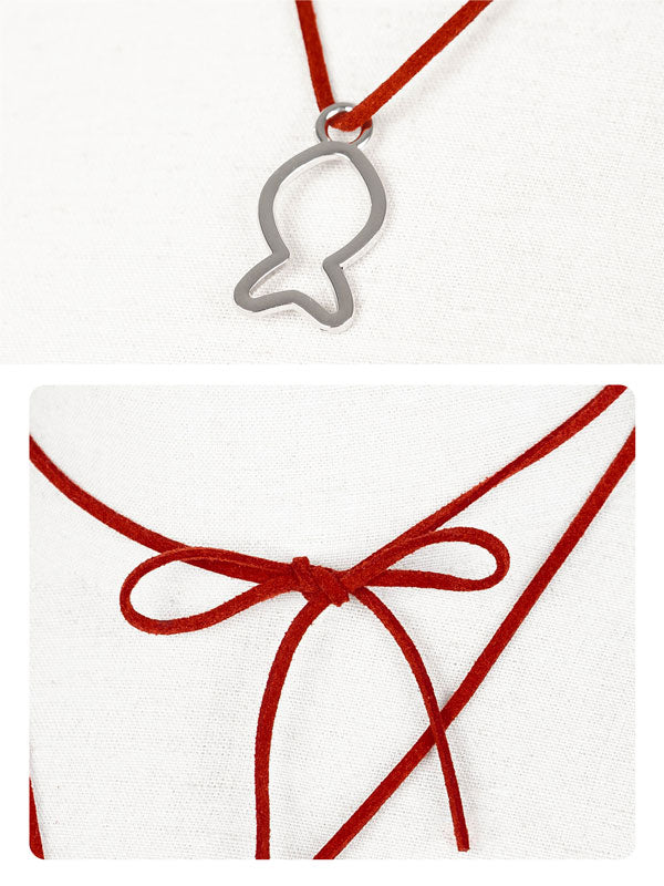Silver fish-shaped pendant on a red cord with a white card featuring a red ribbon.