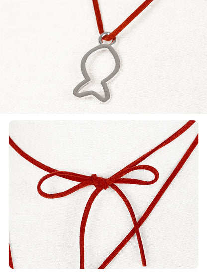 Silver fish-shaped pendant on a red cord with a white card featuring a red ribbon.